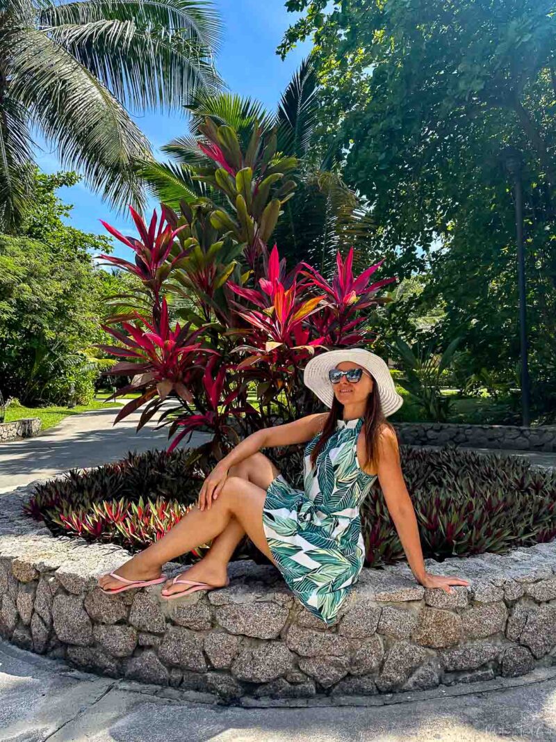 Valentina wearing a green dress and a white hat inside a resort in Mahe in SEychelels