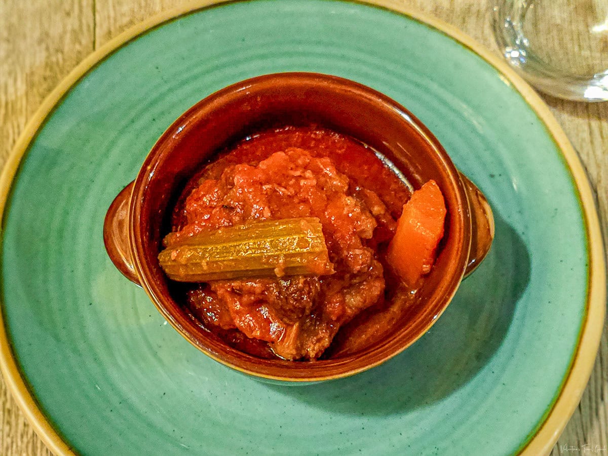 Close-up of a traditional Roman oxtail stew, Coda alla Vaccinara, served in a ceramic dish, highlighting authentic Italian flavors at restaurants near the Pantheon in Rome