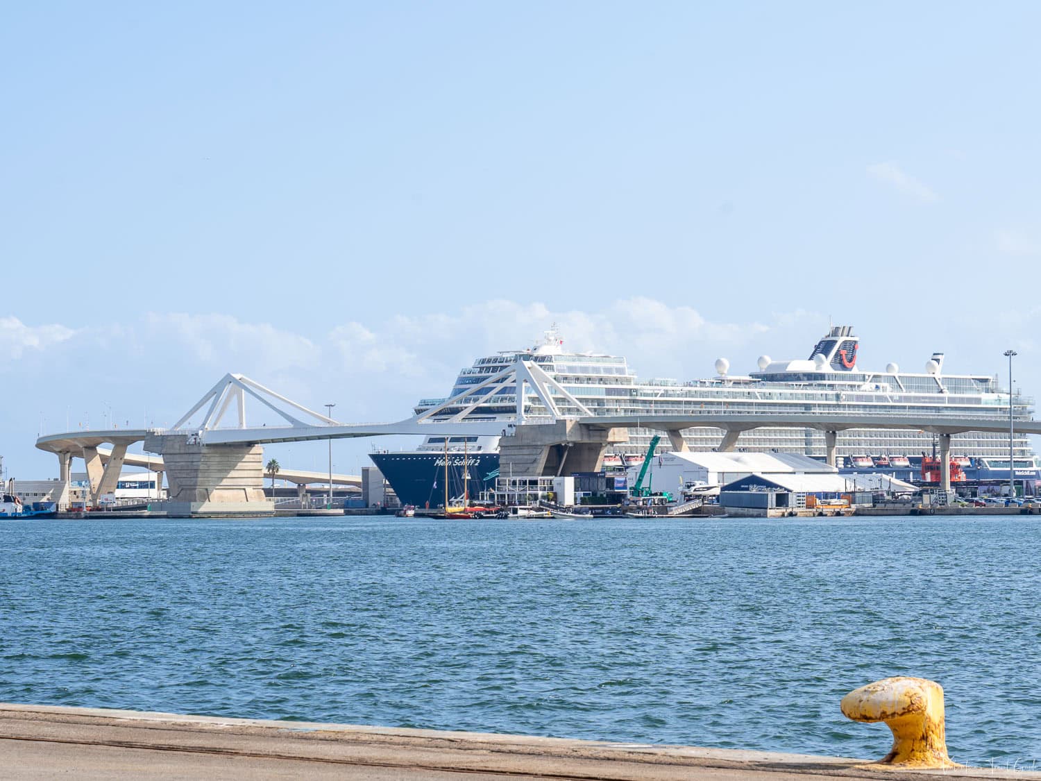 View of a large cruise ship docked beside the striking white cable-stayed Porta d’Europa Bridge at the terminal in Barcelona’s harbor. With its modern facilities and spacious berths, this is the Barcelona port for Royal Caribbean and other major cruise lines, offering easy embarkation and disembarkation for Mediterranean voyages.